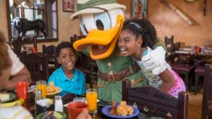 two kids laughing with Donald Duck