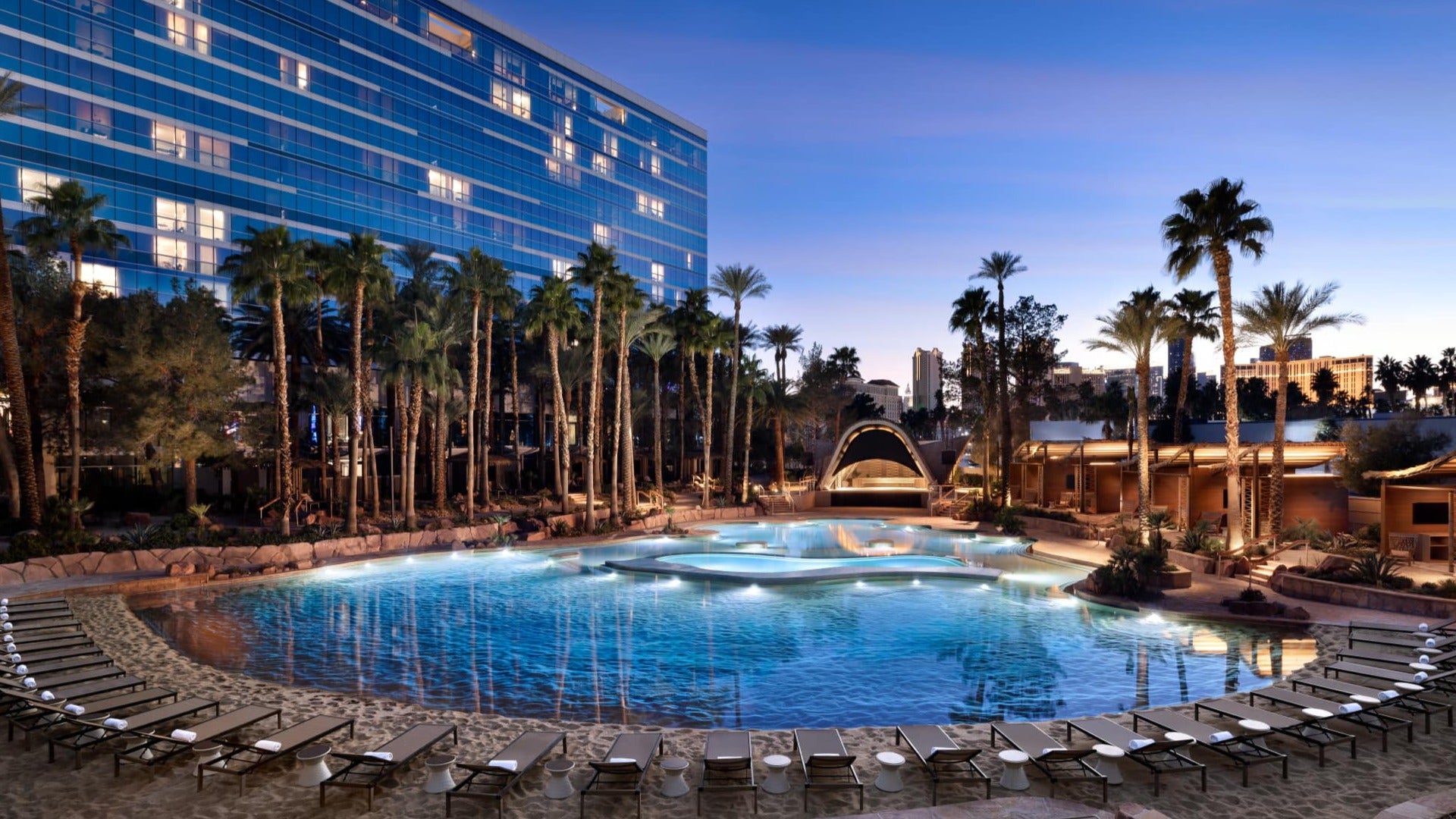 hotel with pool, lounges, and palm trees