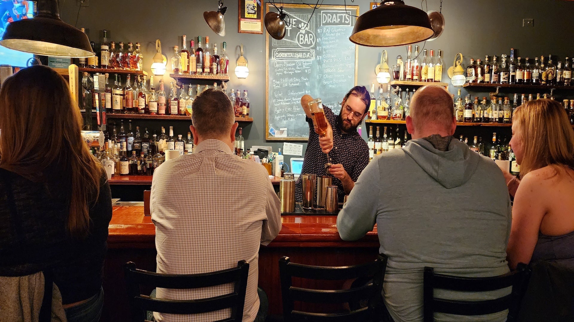 bar with 4 customers and a bartender