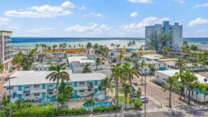 buildings and resorts near the ocean, with palm trees all around