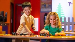 children playing with lego toys, fence and door at the back