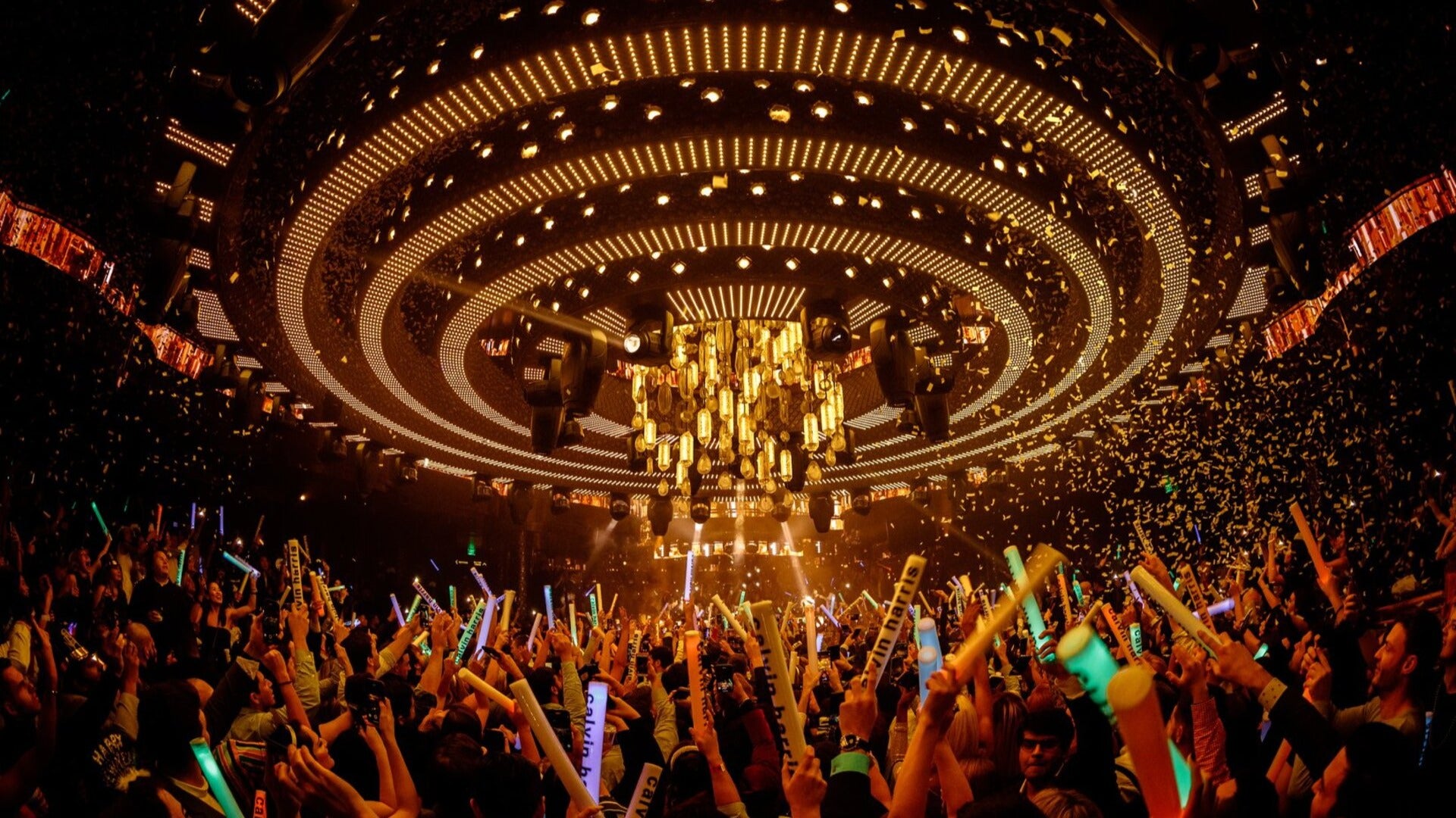 people in a club dancing with confetti and chandelier above