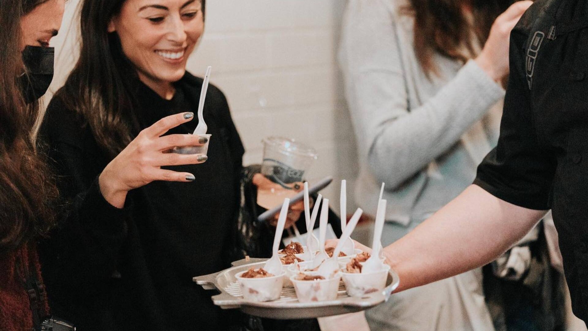 people trying out food in cups with spoons