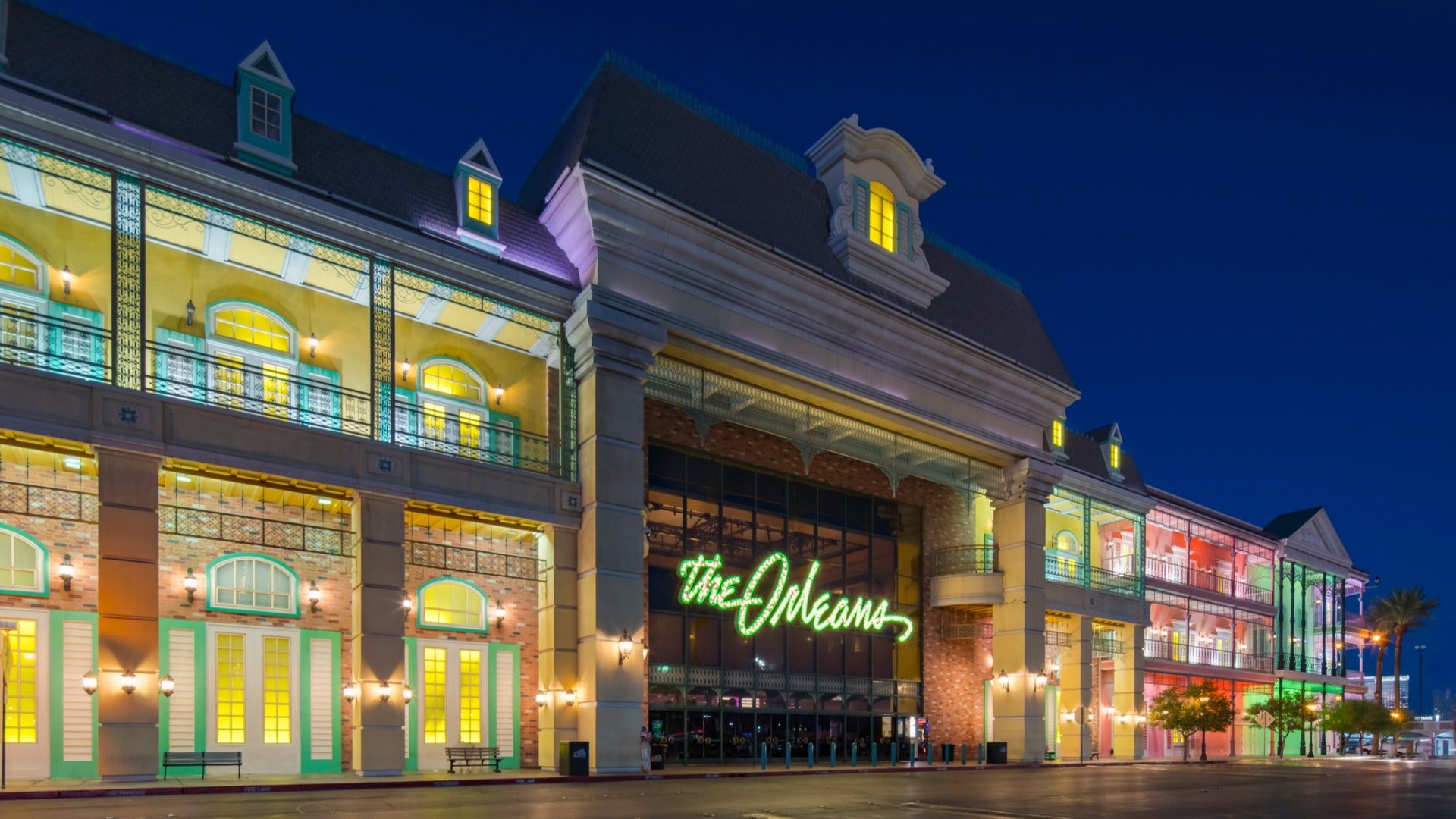 hotel exterior with signage, colorful windows and trees outside