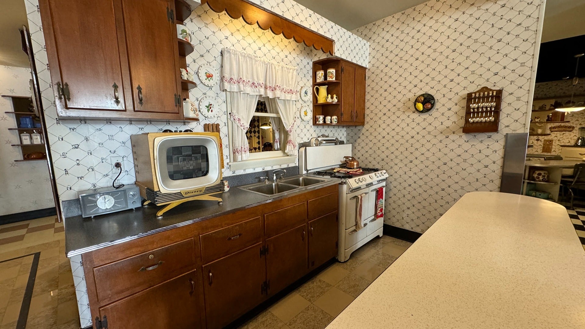 old style diner with tv, curtains, stove, bar counter and cabinets