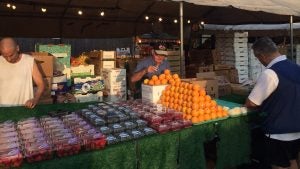 vendor selling fruits to a customer in a farmers market