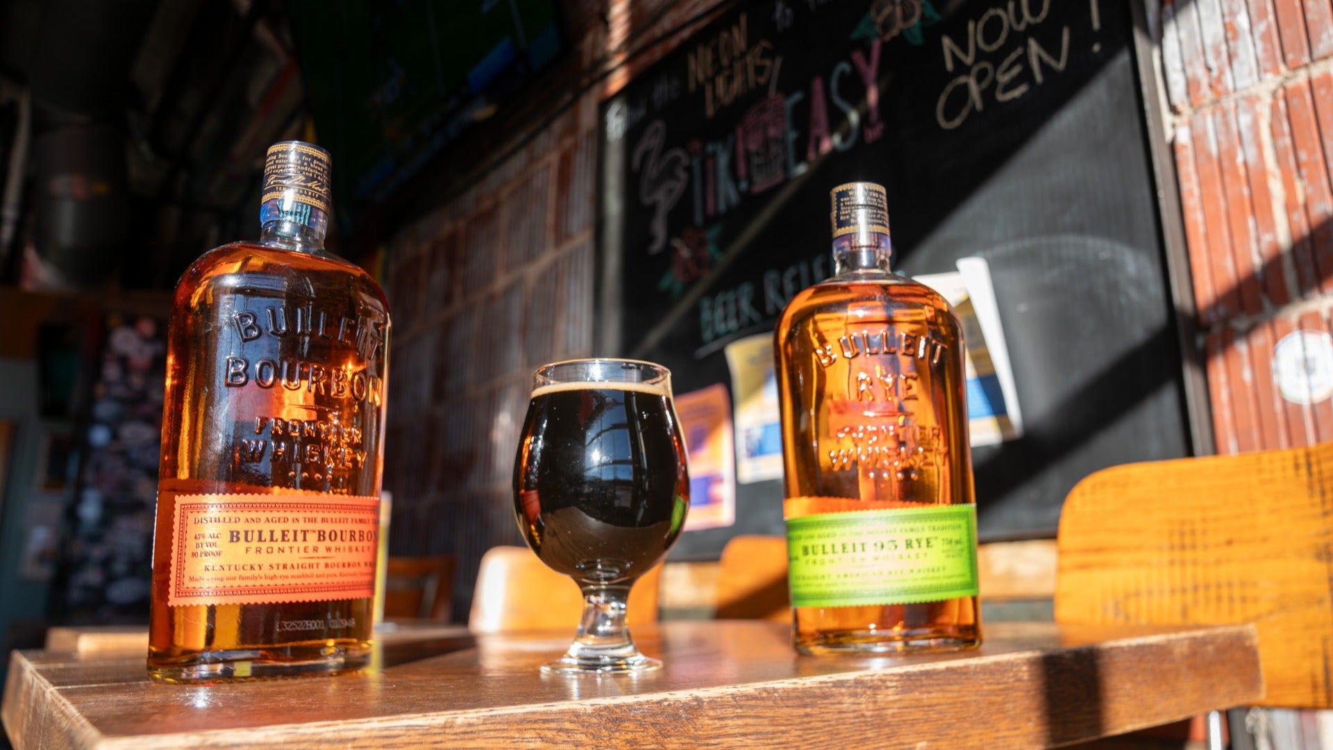 beer and bourbon in glasses, chalkboard at the back