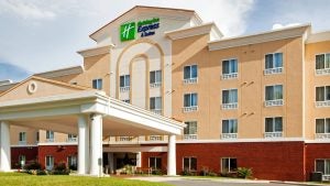 hotel exterior with windows and curtains and lawn in front