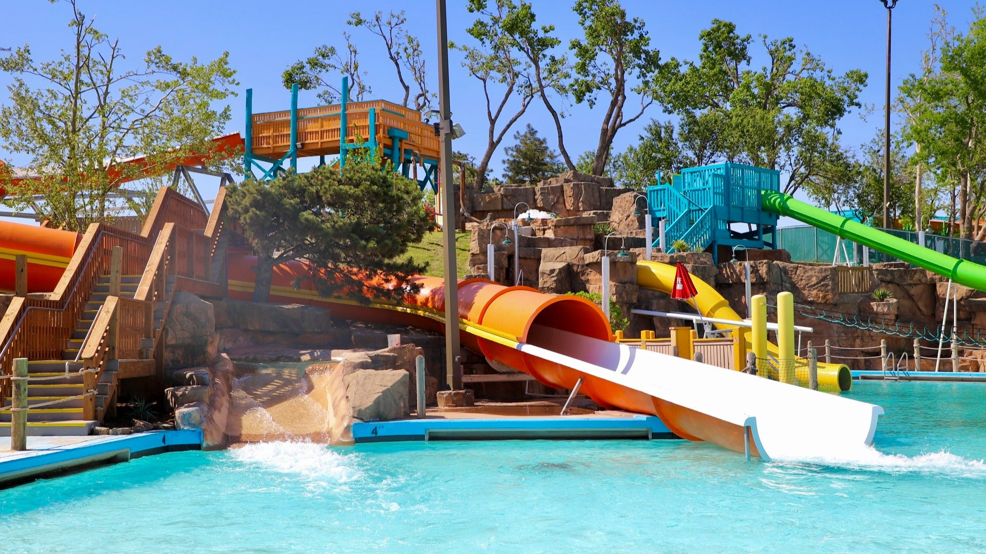 water slide straight to a pool, trees surrounding it