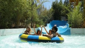 people on a water ride, surrounded by plants