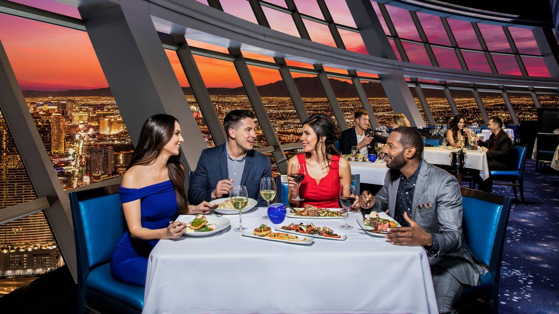 people eating at a restaurant with with a view of las vegas skyline