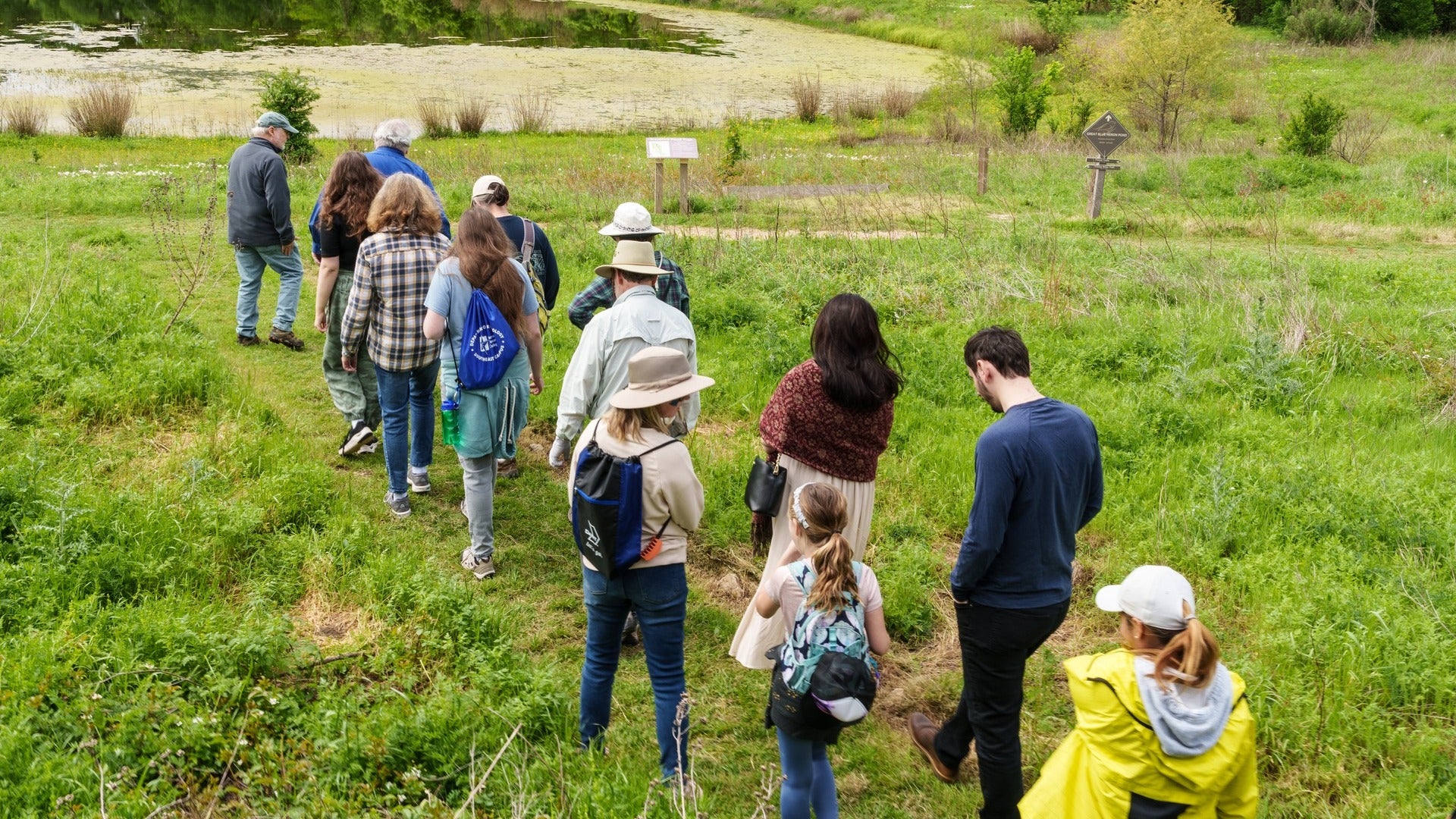 people hiking a trail beside a river