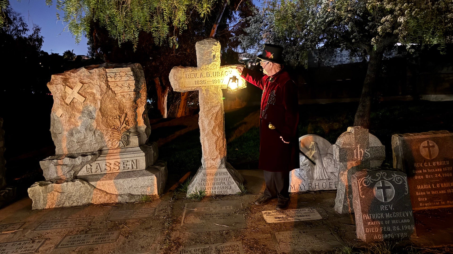 Tour guide standing next to gravestones in a park