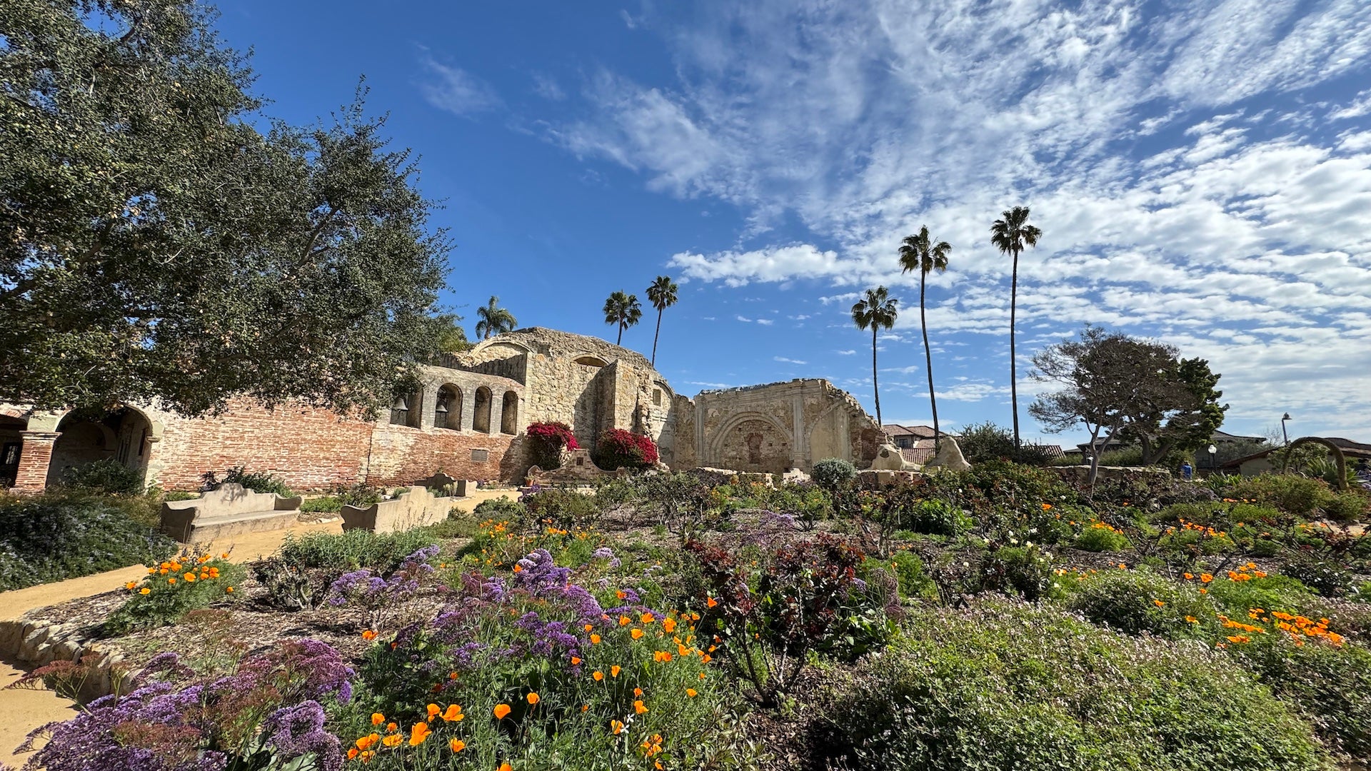 Gardens and an old stone mission in the background