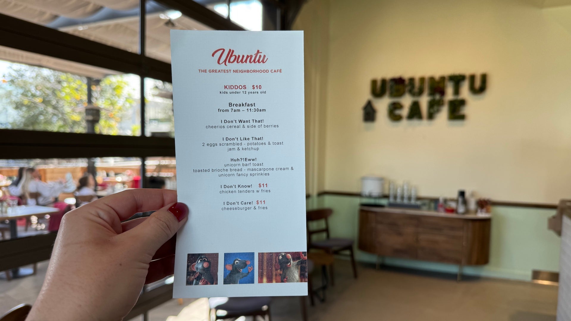 A hand holding up a menu inside of a cafe