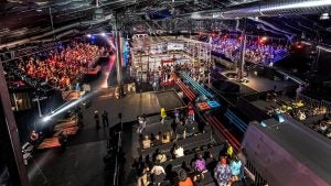 people in an arena watching a battle of robots