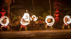 men doing a fire dance in costume at a luau