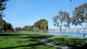 golf course with view of water and bridge at the back, surrounded by trees