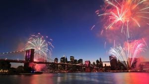 fireworks over a bridge and river with city skyline view