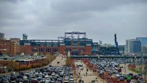 cars in a parking lot, view of stadium at the back