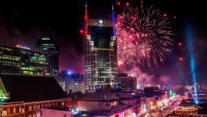 fireworks over a city with crowd below