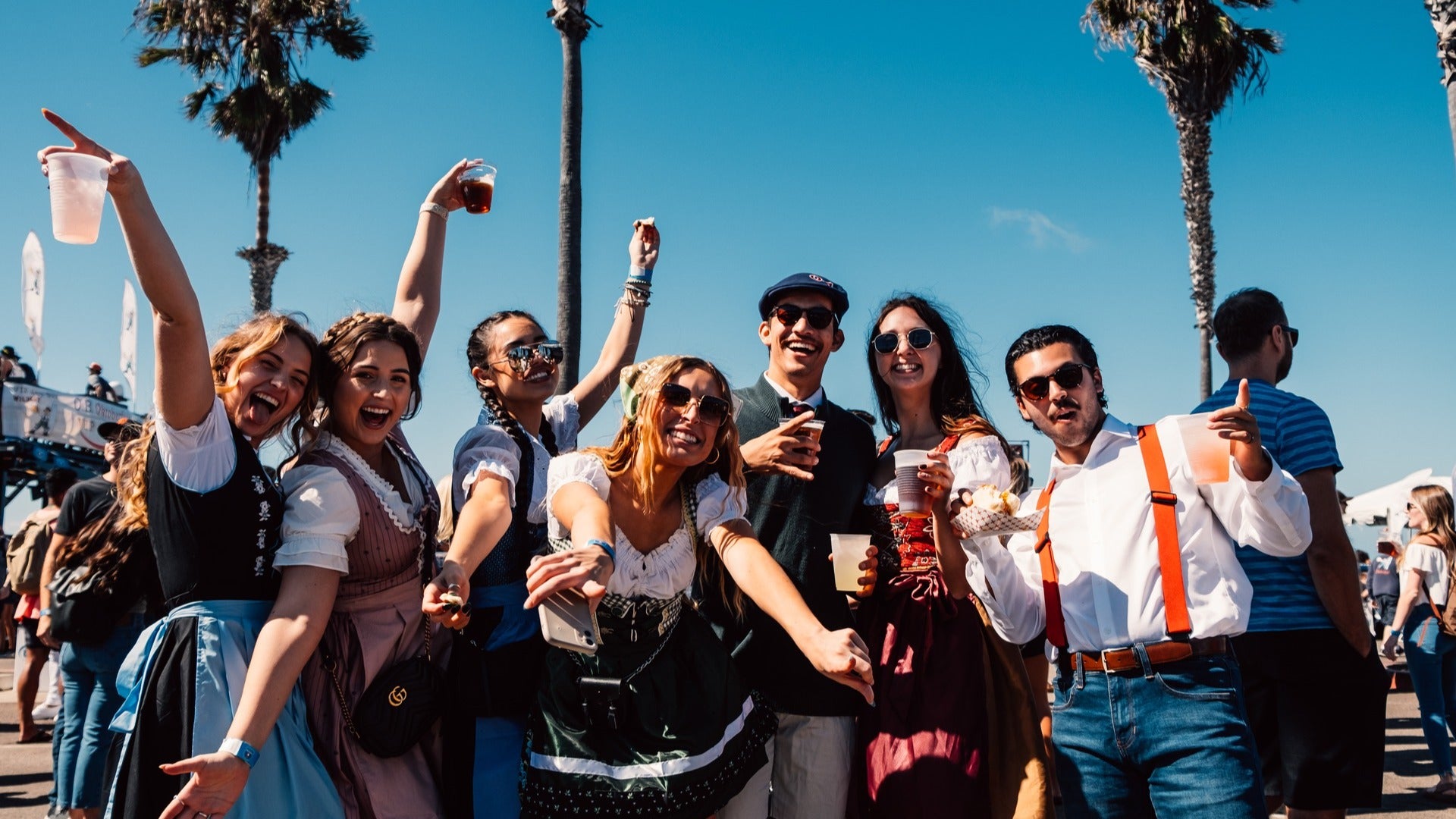 group of people drinking beer with palm trees at the back