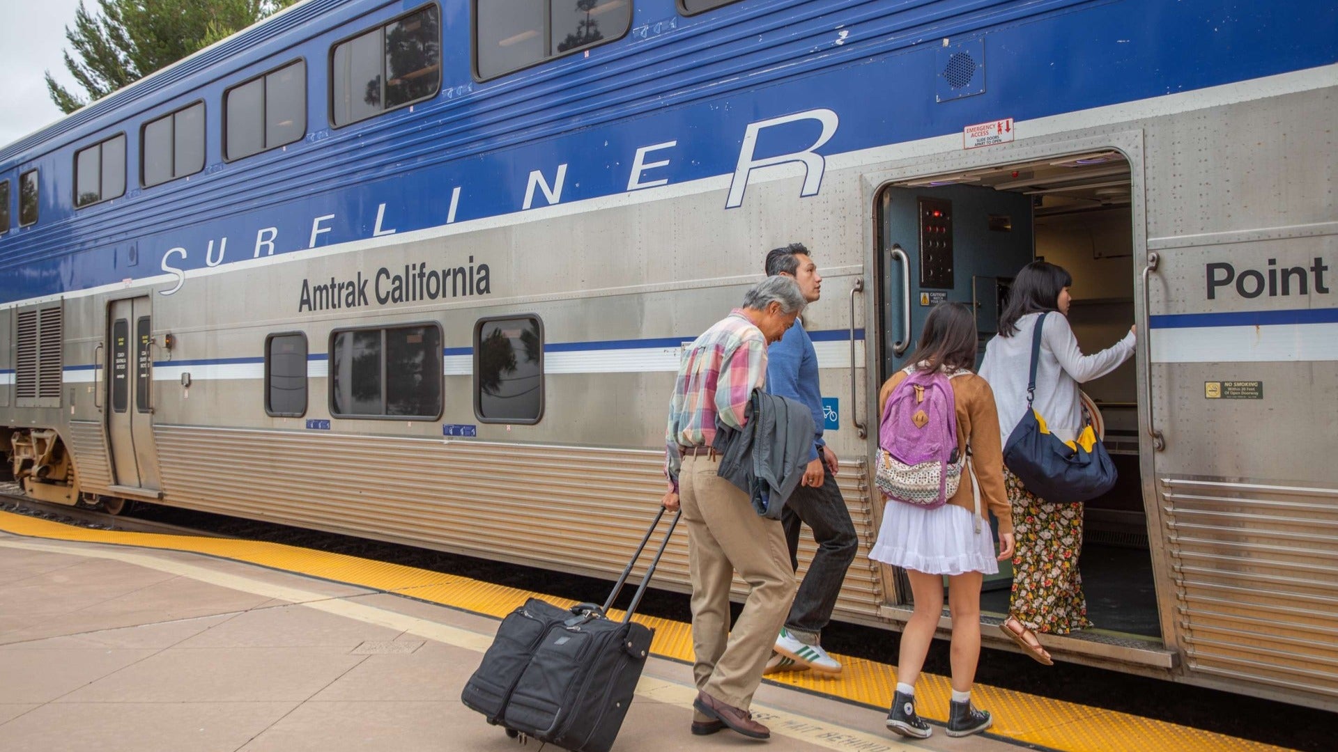 people boarding a train with luggage and bags