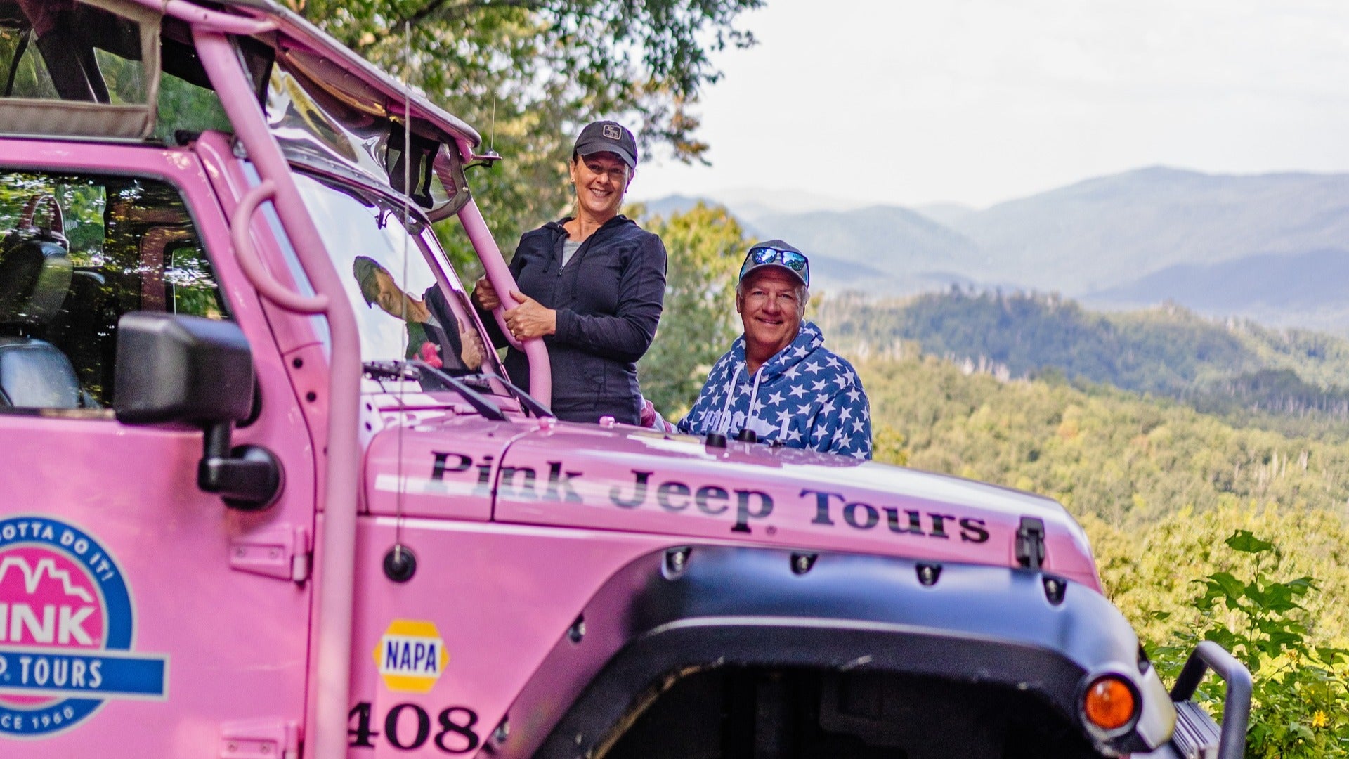 couple on a pink jeep with view of smoky mountains