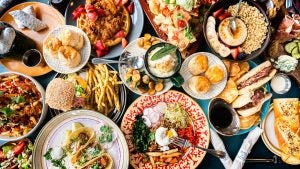 a lot of plates with food like burgers, fries, waffles, tacos