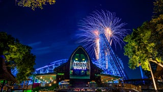 Fireworks bursting in the night sky over the Iron Gwazi roller coaster at Busch Gardens Tampa