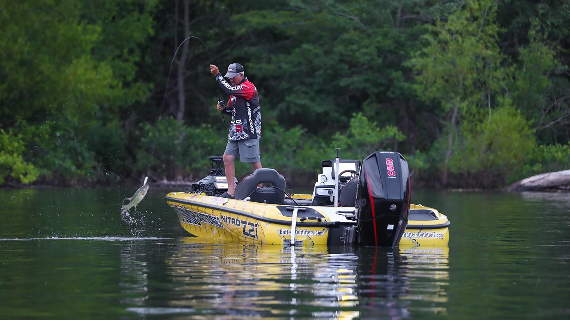 man on a boat fishing in a lake