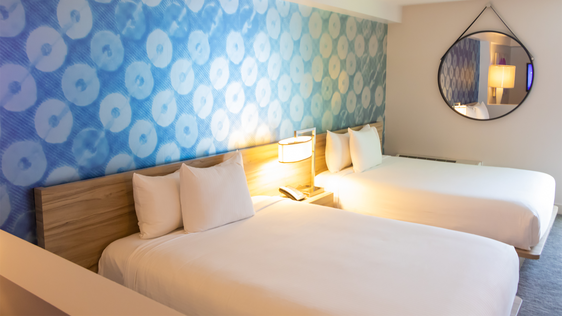 hotel room with two beds and mirror, and lamp