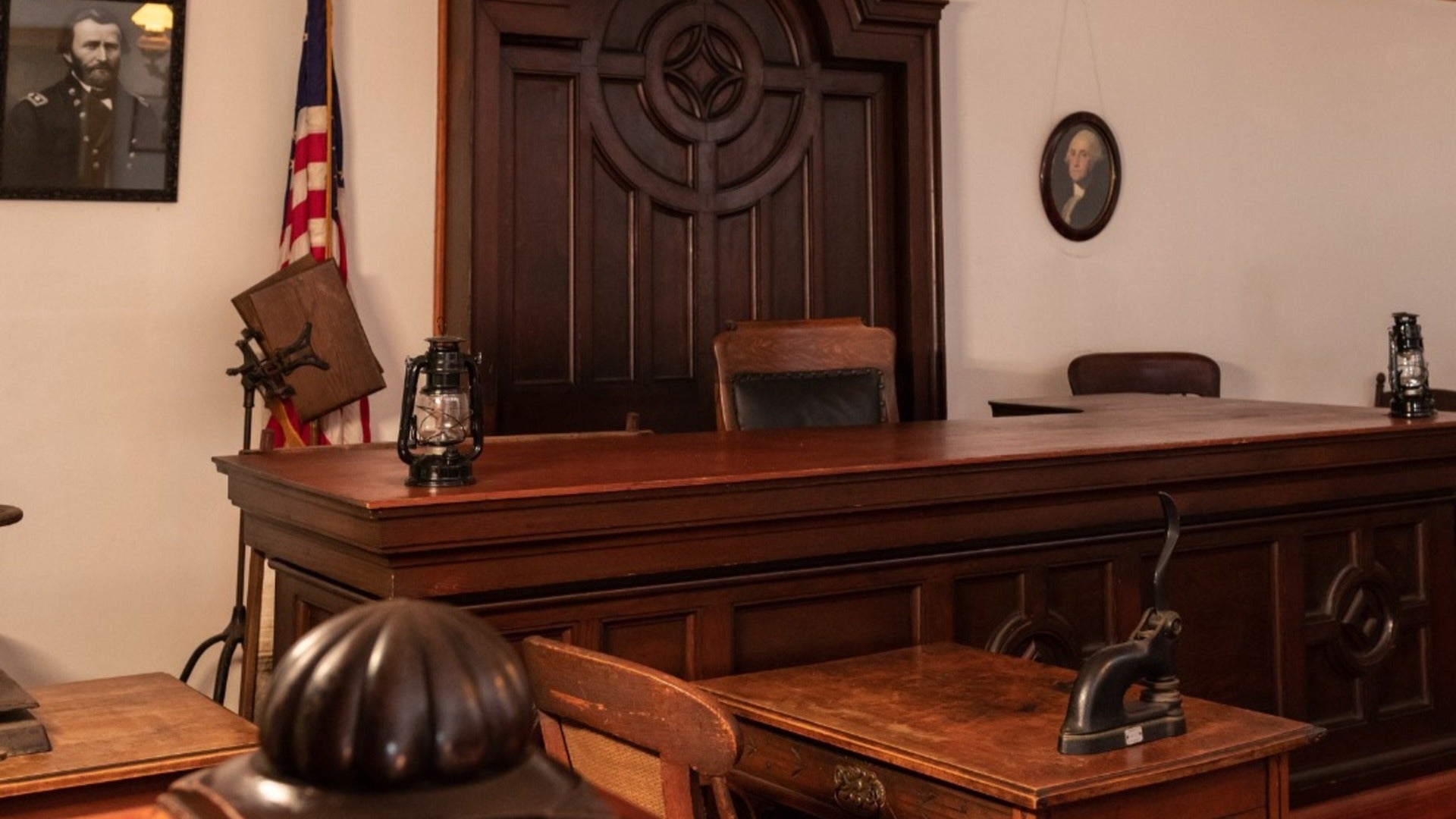 hearing room with portraits on wall and chairs and flag