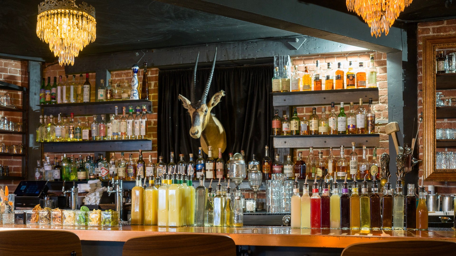 A well stocked bar with an antelope on the wall behind it