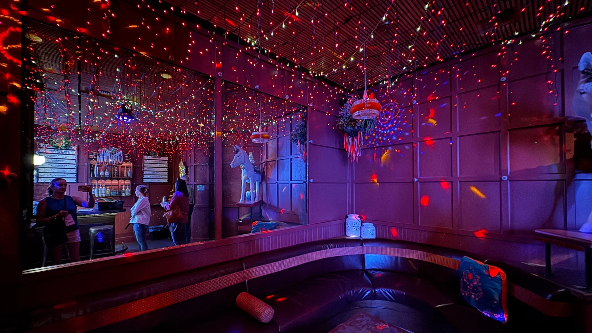 Seating area with ambient purple and red lighting at Ghost donkey