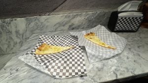 Two slices of pizza on checkered paper