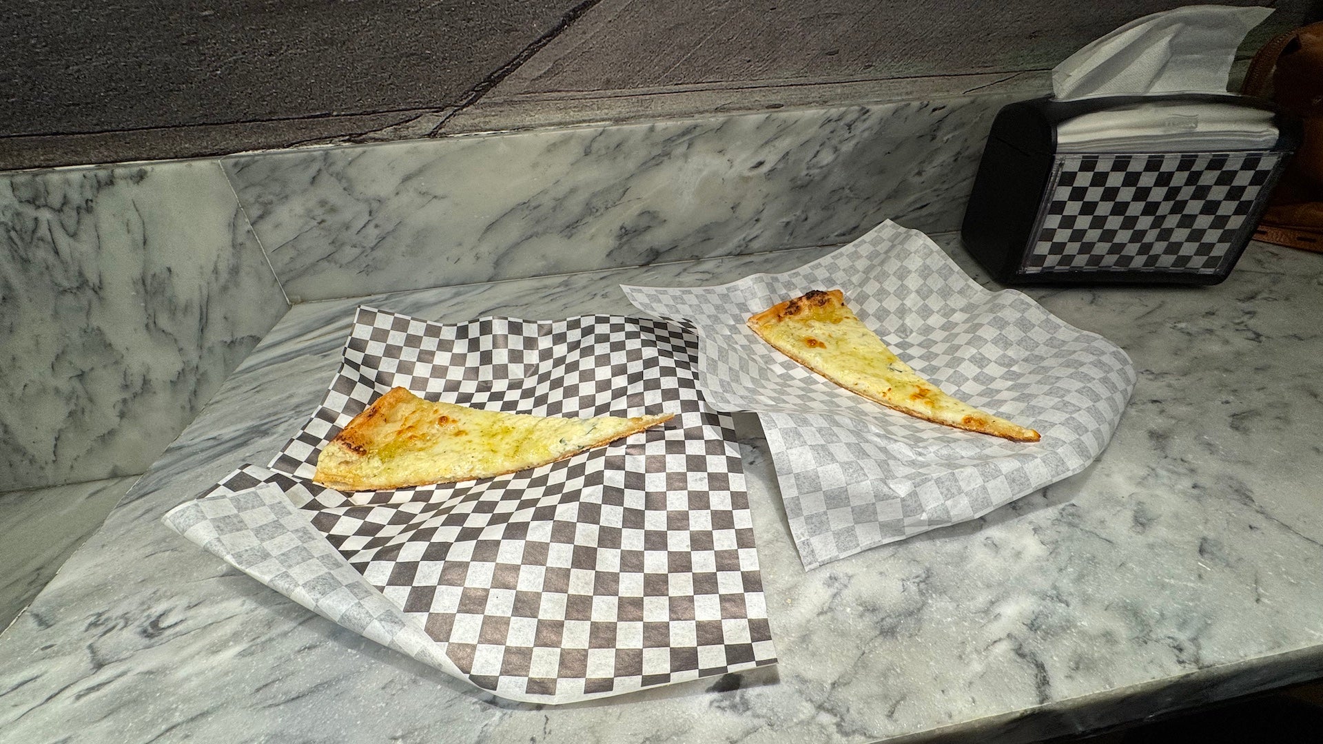 Two slices of pizza on checkered paper