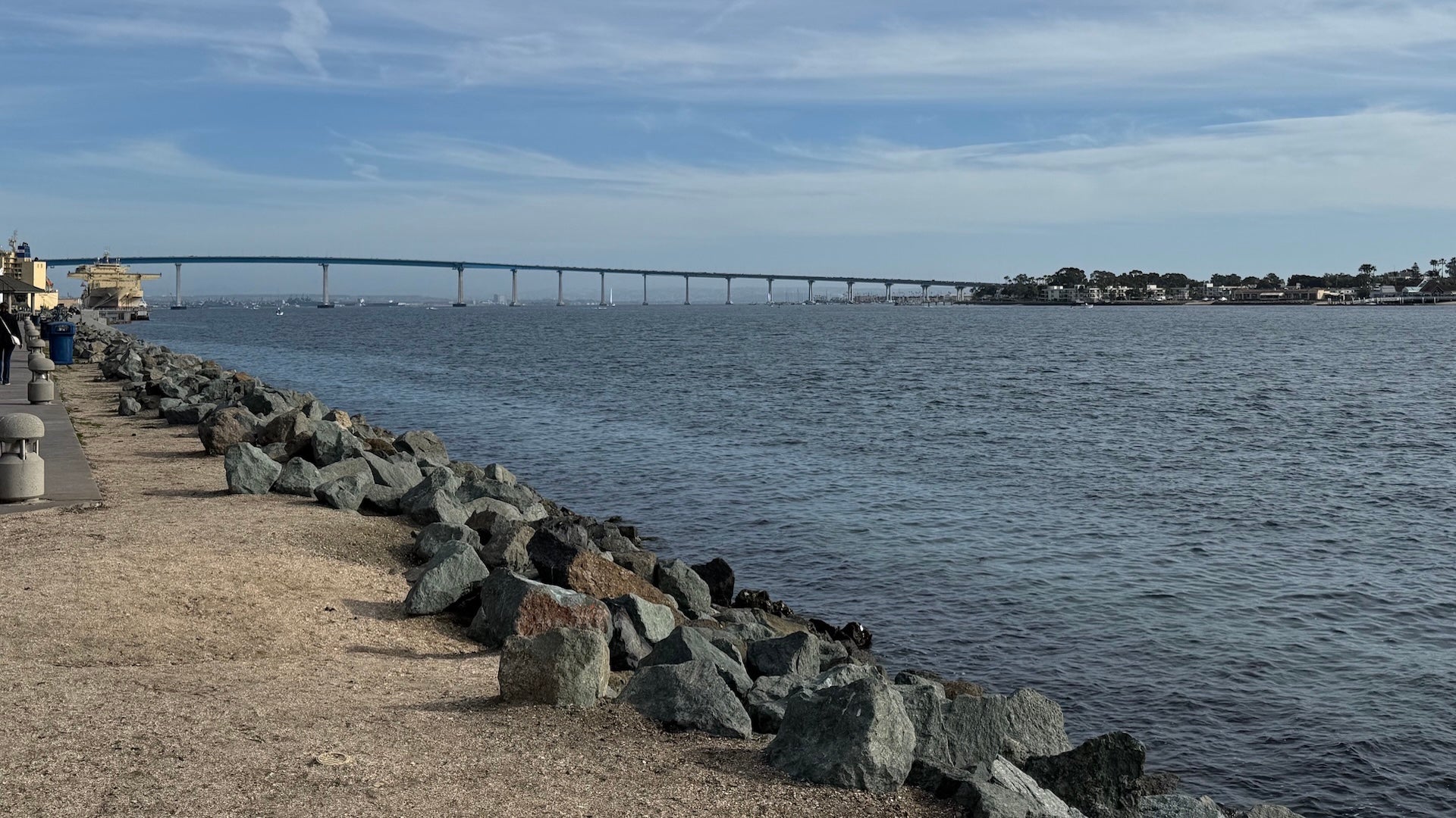 beach with rocks and a bridge
