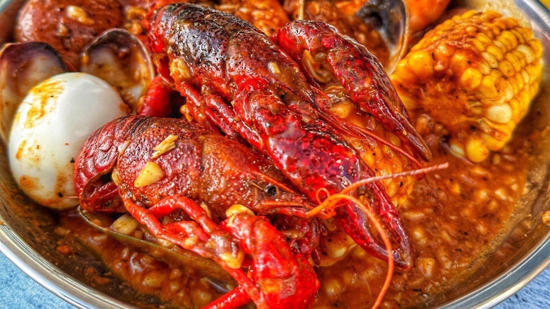 lobsters, corn, and an egg in a bowl