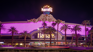 hotel exterior with signage and palm trees lining the street in front