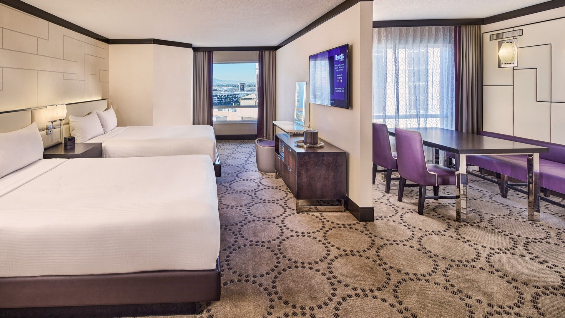 hotel room with two beds, work space, tv, and window