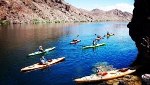 people in kayaks on a lake