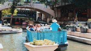 people aboard a boat on the san antonio river
