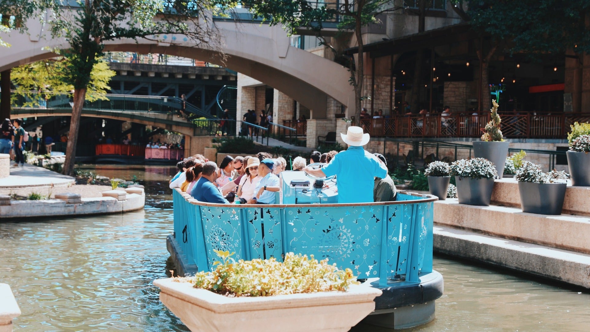 people aboard a boat on the san antonio river