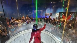 indoor skydiving instructor in flight while people watch