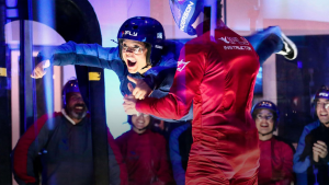 woman in an indoor skydiving facility with instructor