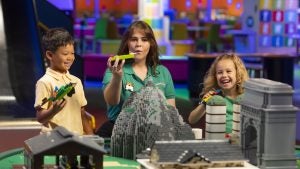 Two kids and a adult playing with legos at legoland Chicago