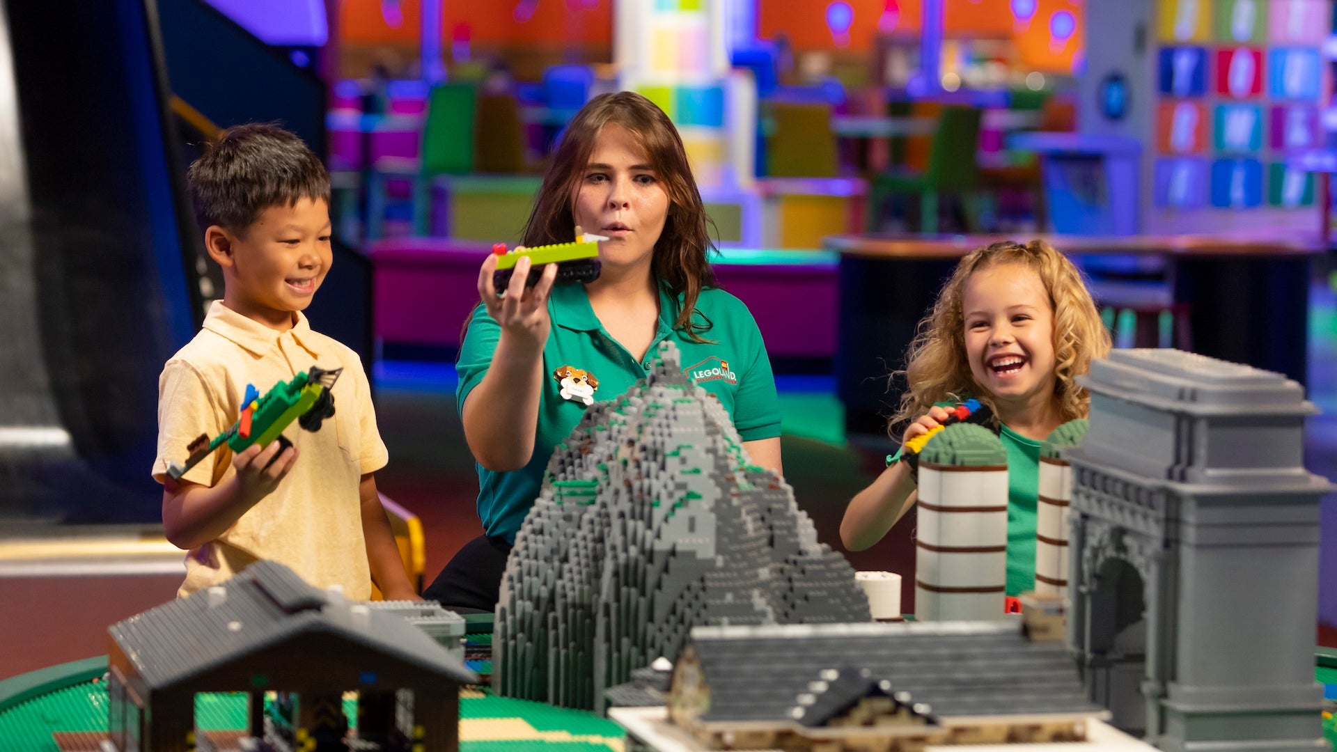 Two kids and a adult playing with legos at legoland Chicago