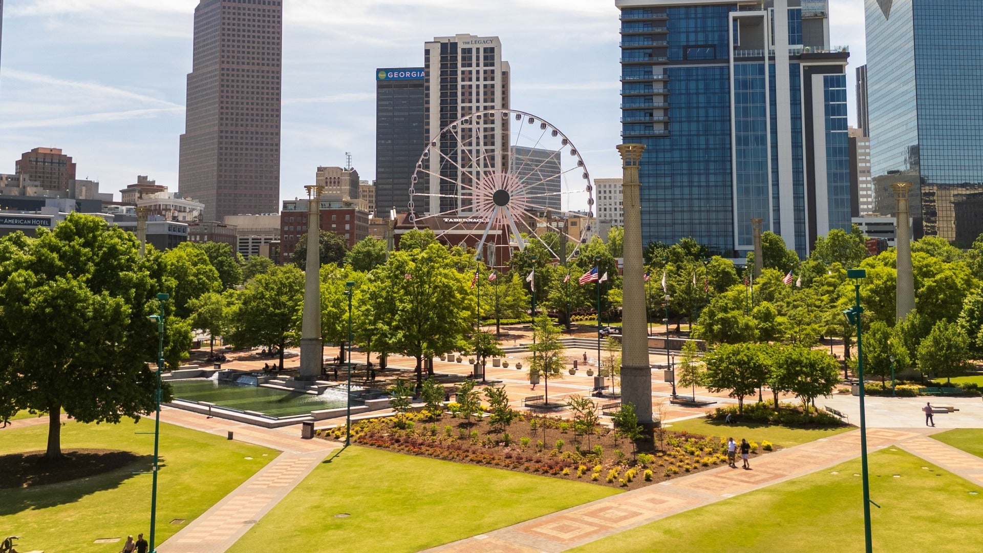 outdoor park with ferris wheel and buildings in the background