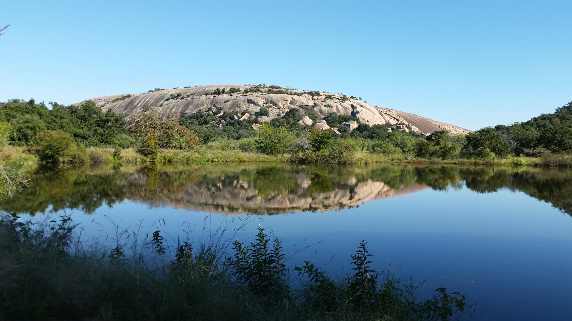 dome-shaped rock reflecting on water